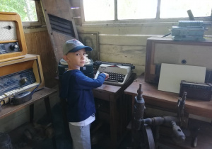 chłopiec pokazuje maszyną do pisania